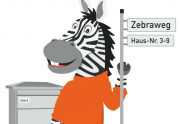 Zebra mit Straßenschild und Briefkasten